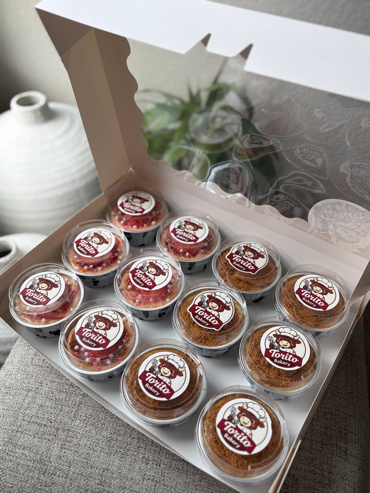 Open Torito Bakery event box with 12 individual cheesecakes arranged for a party or dessert table.